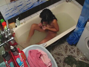 Брюнетка мастурбирует письку лежа в ванне